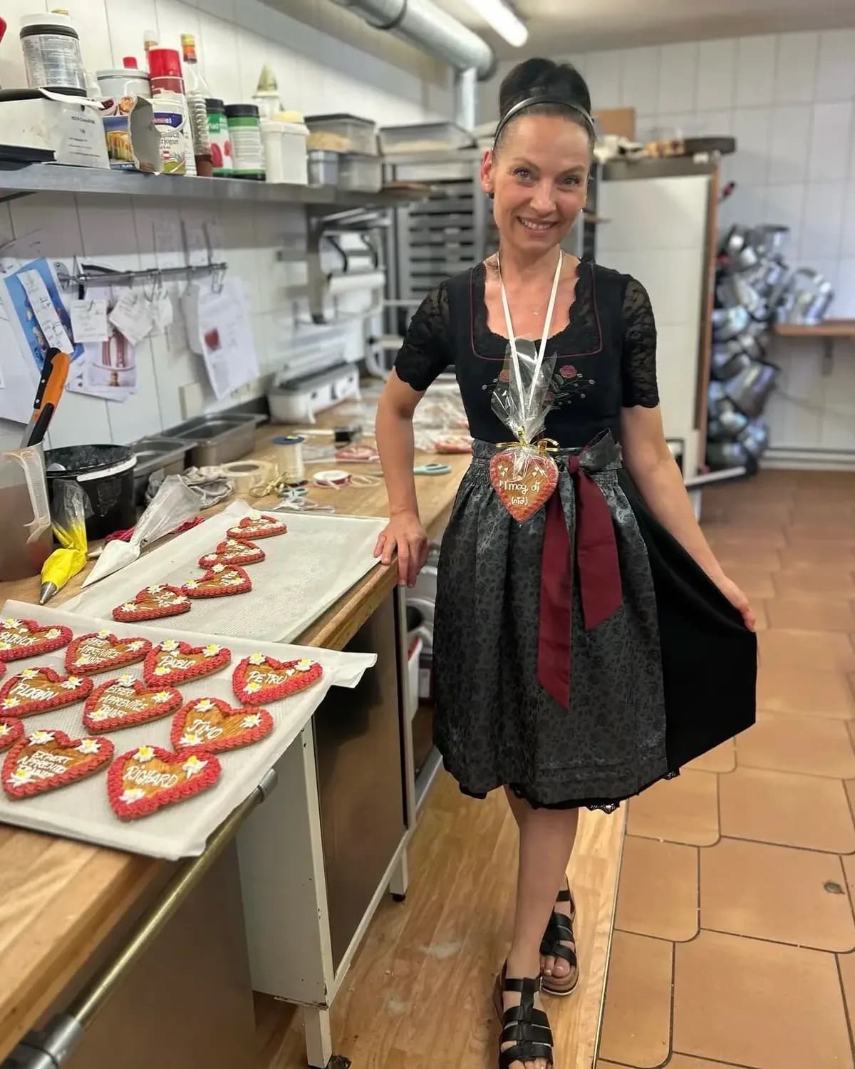 Silvia in ihrer Backstube, vor ihr Bleche mit verzierten Lebkuchenherzen