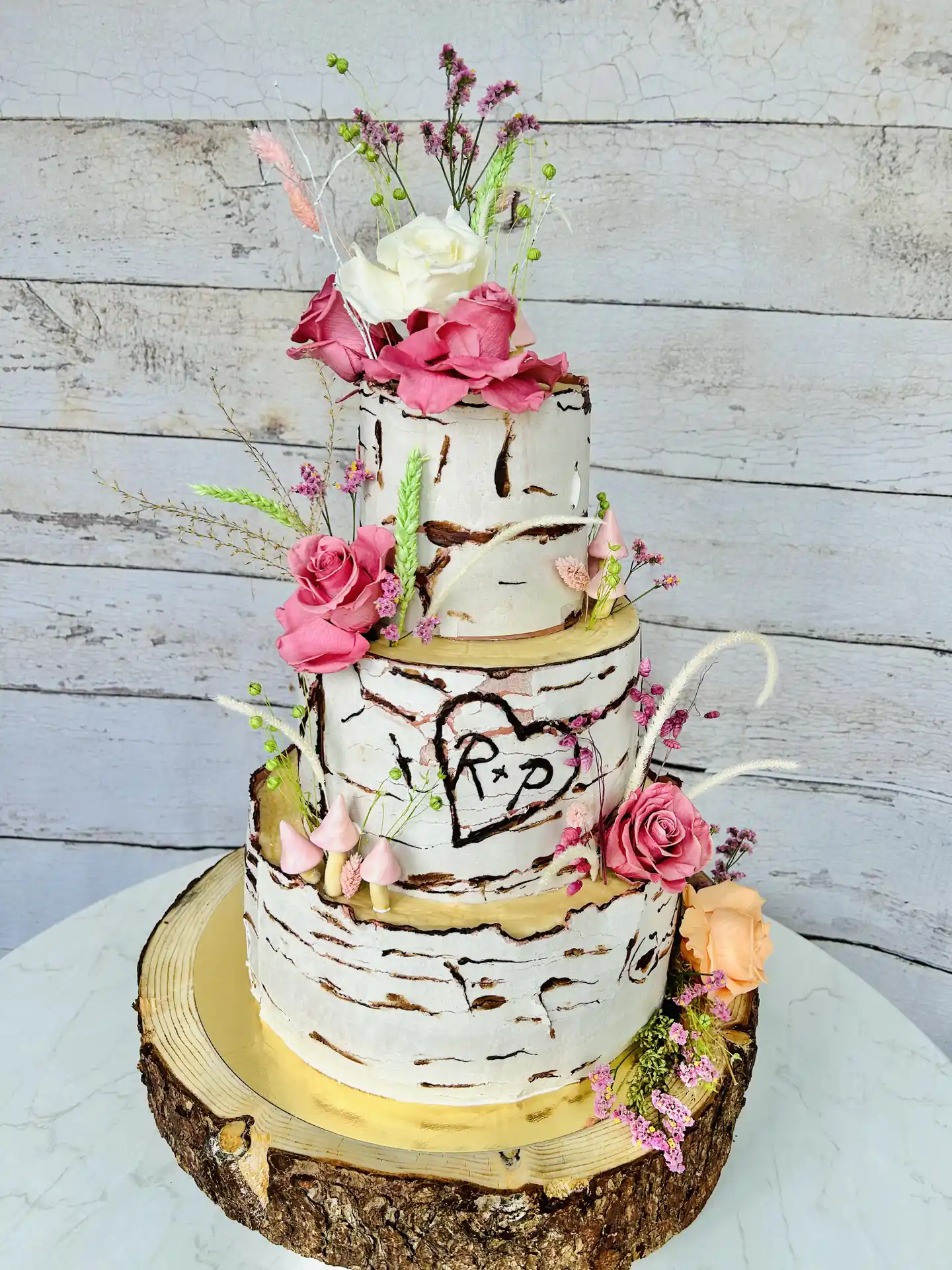 Dreistöckige Hochzeitstorte im Birkenrinden-Look mit rosa Rosen und Wiesenblumen