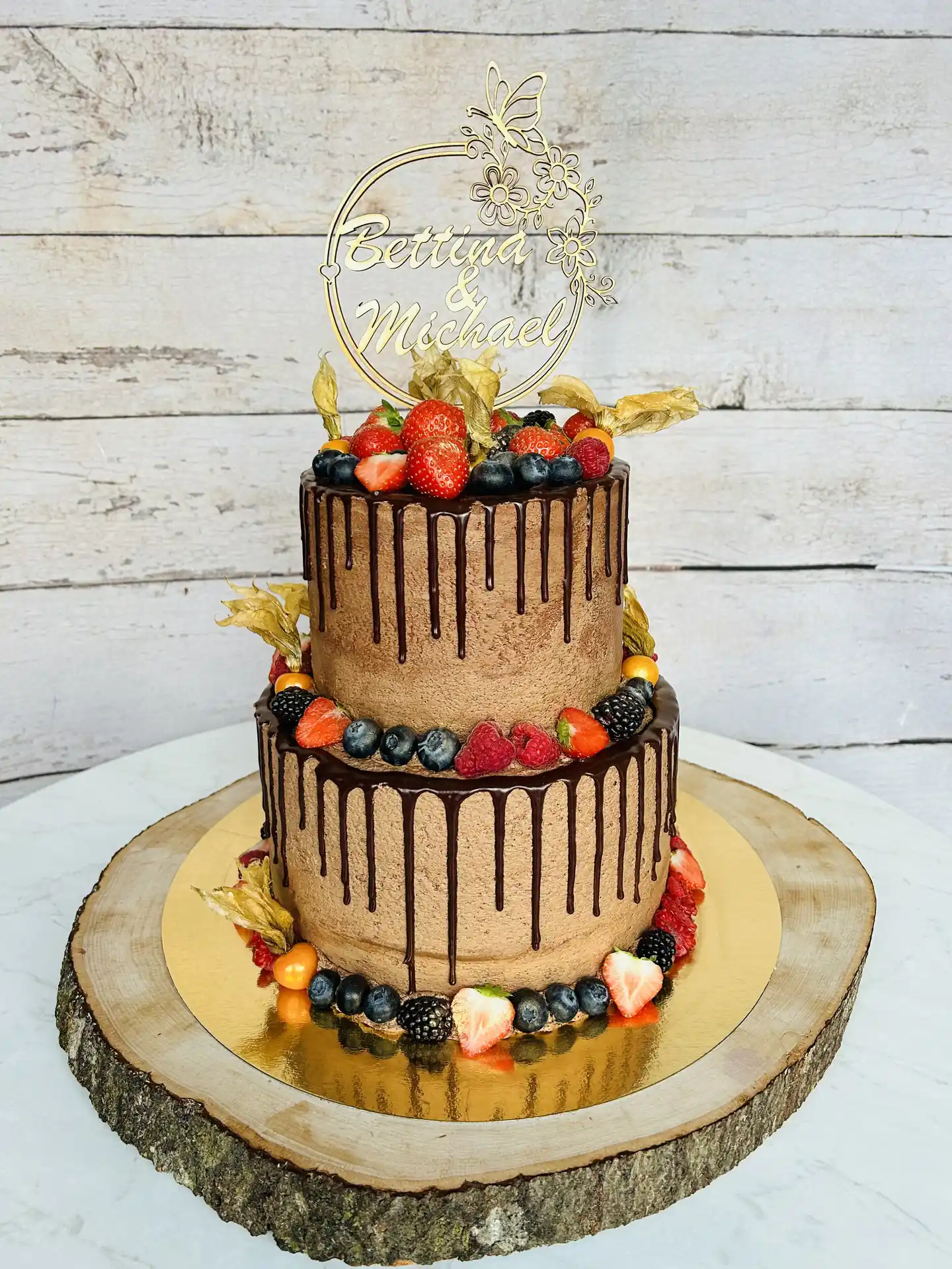 Zweistöckige Schokoladen-Hochzeitstorte mit Drip-Glasur und frischen Beeren