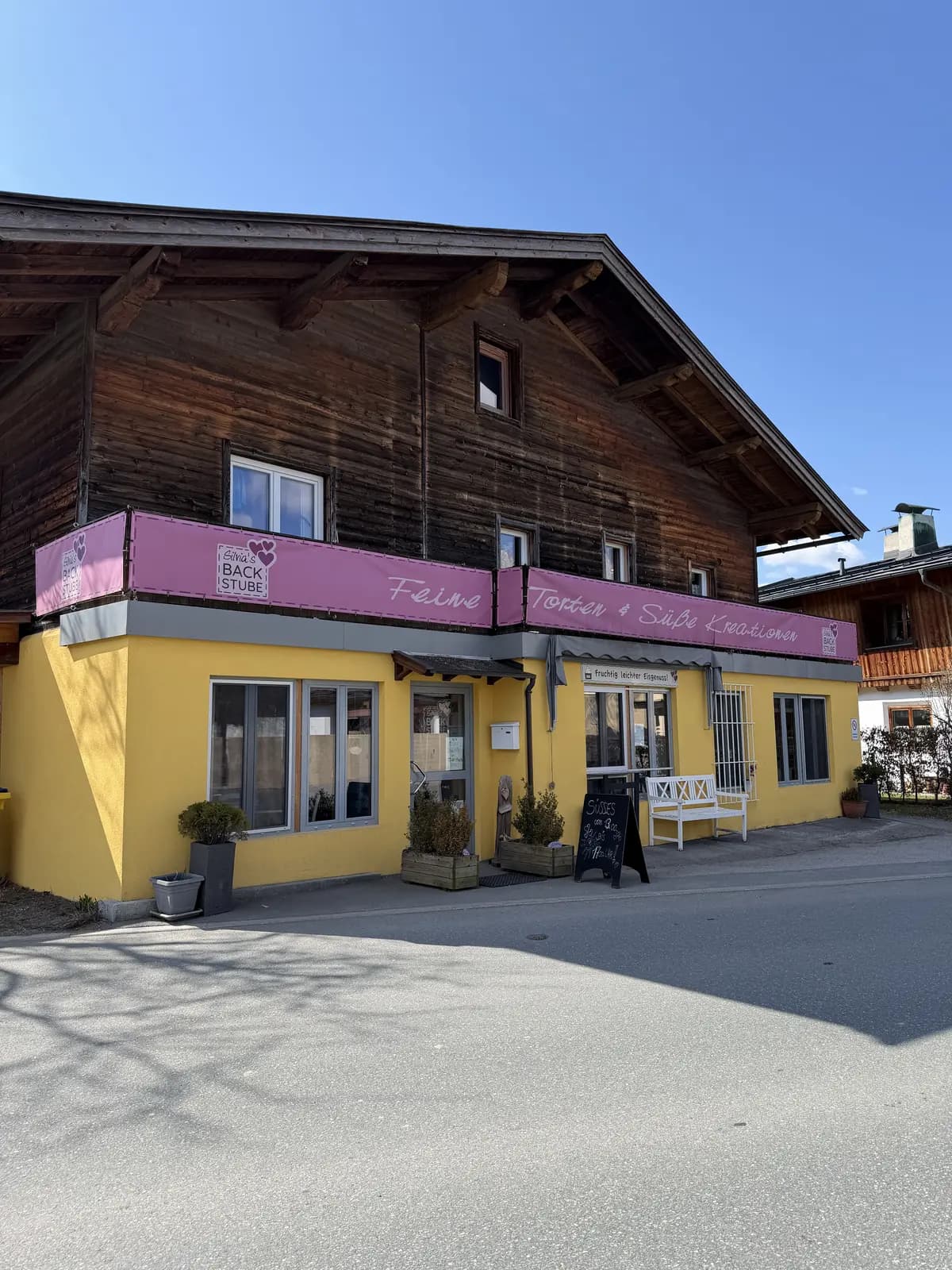Silvias Backstube von der Seite: das gelbe Haus mit dem Schriftzug Feine Torten und Süße Kreationen