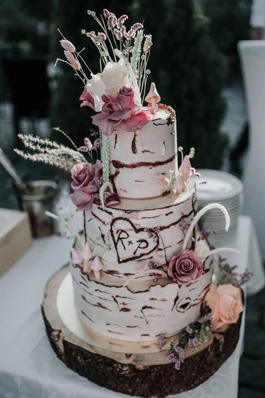 Birkenrinden-Hochzeitstorte mit Trockenblumen auf der abendlichen Hochzeitstafel