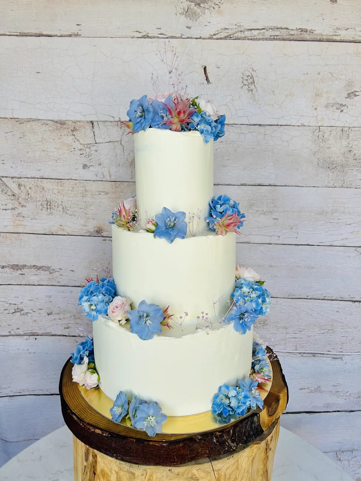 Dreistöckige weiße Hochzeitstorte mit blauen Hortensien