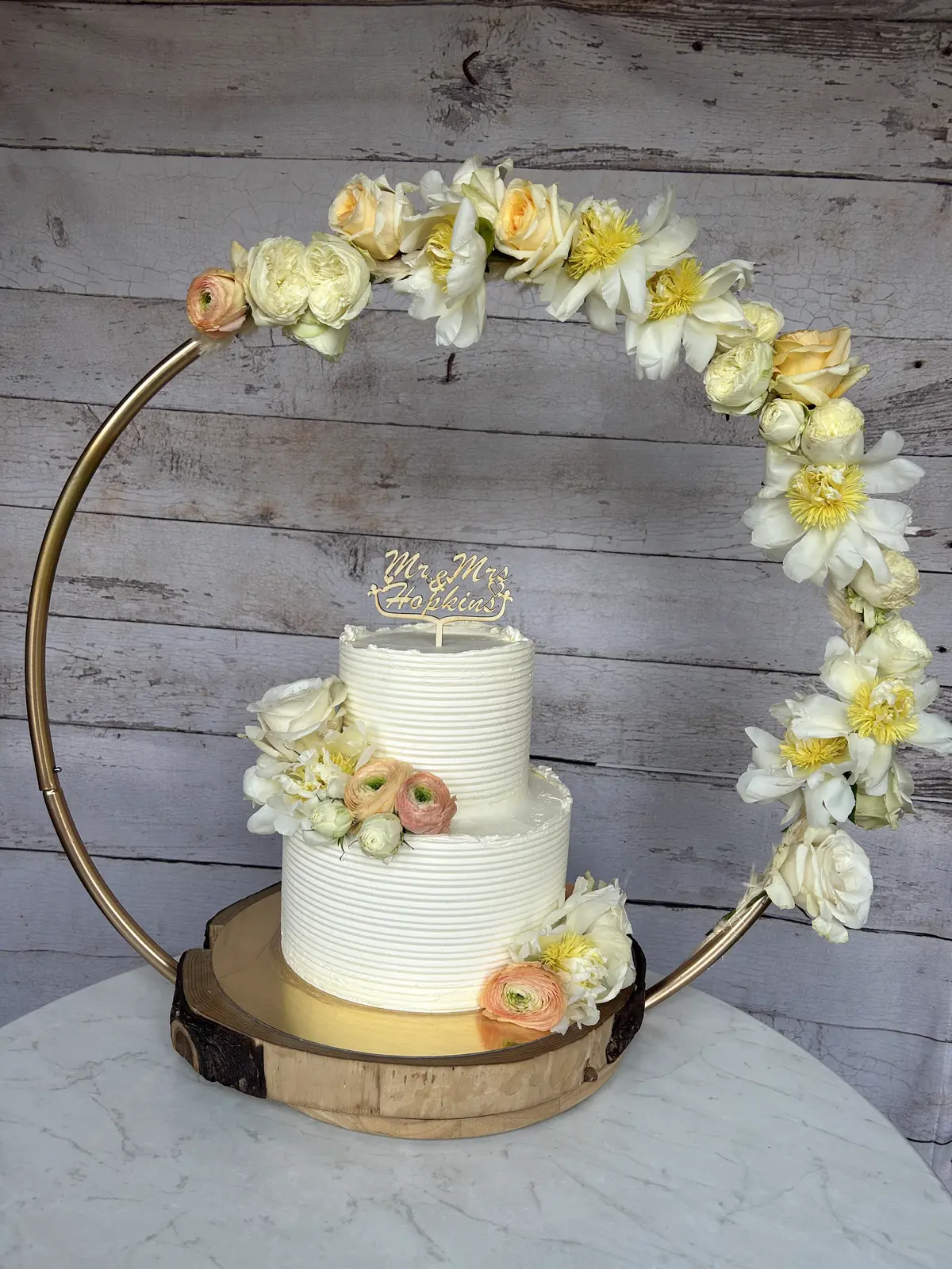 Elegante Hochzeitstorte mit Blumenarrangement